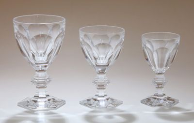 trois verres à vin vides posés sur une table devant un fond blanc