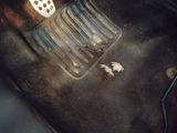 a car floor with a dirty floor mat and a car floor drain