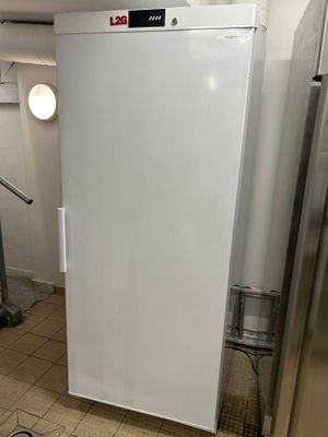 un réfrigérateur blanc qui se trouve dans une pièce au sol carrelé