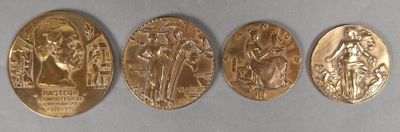 quatre médailles d'or de tailles et de formes différentes sur un fond blanc