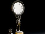 une statue représentant une femme tenant un miroir, posée sur un socle