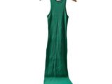 La robe verte est suspendue à un cintre sur un fond blanc.