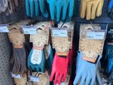 many pairs of gardening gloves on display in a store