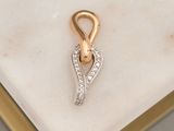 a close up of a gold and diamond pendant on a marble surface