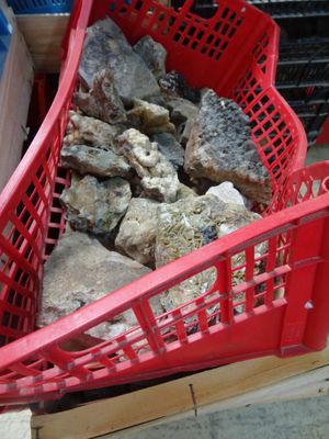 a red basket full of rocks on the ground