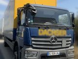 un camion qui roule sur la route avec une caisse jaune à l'arrière