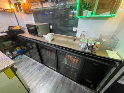 a counter with a refrigerator and a microwave in it