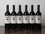 six bouteilles de vin rouge sont alignées sur une table en bois