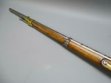an old gun with a wooden handle on a white surface