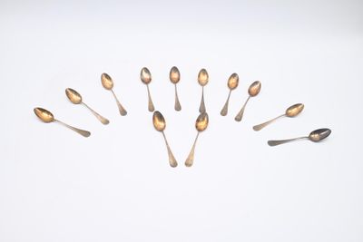 de nombreuses cuillères disposées en cercle sur une surface blanche