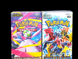 two packs of pokemon trading cards on a black background
