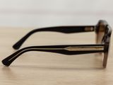 sunglasses on a wooden table with a white wall in the background