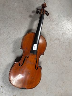 un vieux violon posé par terre dans une pièce