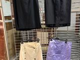 three pairs of skirts hanging on a wire rack in a store