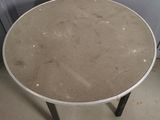 a round table with a metal base in a room