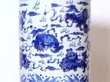 un vase bleu et blanc posé sur une étagère blanche