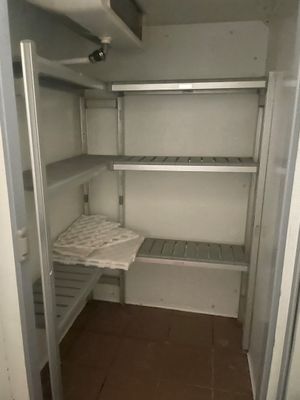 une photo d'un placard vide avec des étagères et un lit