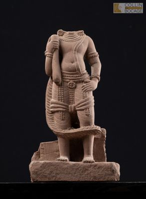 a statue of a man standing on top of a stone block