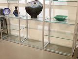 a glass shelf with vases on it in a living room
