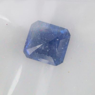 a blue diamond that is sitting on a white surface