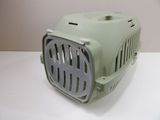 a small green pet carrier on a white table