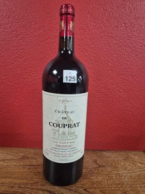 a bottle of red wine sitting on a wooden table