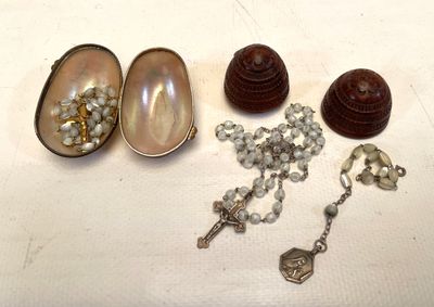 une petite boîte contenant des perles et un chapelet, posée sur une table
