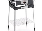 un barbecue noir et blanc muni d'une plaque de cuisson posée sur un support