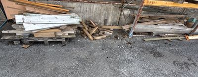 un tas de bois posé par terre à côté d'un bâtiment