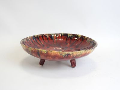 a picture of a red and yellow bowl sitting on a stand