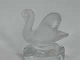 a glass swan figurine sitting on top of a clear base