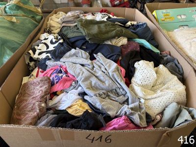 a cardboard box filled with clothes and a stuffed animal