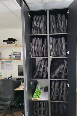 une grande armoire métallique sur laquelle sont posés plusieurs sacs à dos
