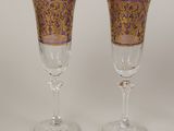 two wine glasses with gold and purple designs on them