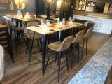 tables and chairs in a restaurant with wooden floors and a bar