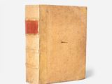an old book sitting on top of a white surface