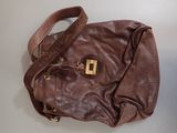 brown leather handbag with a gold buckle on a white surface