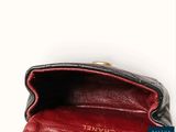 the black and red purse is open on the white surface
