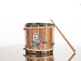 a small drum with a wooden stick on a table