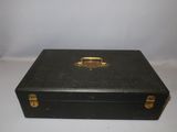 a black suitcase with a gold handle on a white table