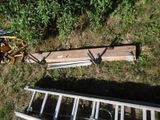 a pile of wood sitting on the ground next to a ladder