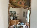 a large mirror hanging on the wall above a dining room table