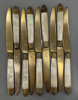 six knives are lined up in a row on a table