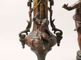 pair of bronze statues of a woman and a man on marble bases