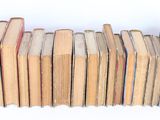 many books stacked on top of each other on a shelf