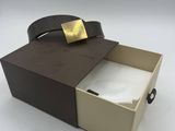 une boîte ouverte sur laquelle est posée une ceinture en cuir
