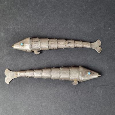 pair of antique silver fish figurines with turquoise eyes