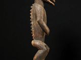 a wooden statue of a man with a large head and legs