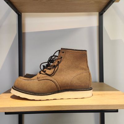 un gros plan sur une paire de bottes marron posées sur une étagère en bois