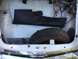 the trunk of a car with a tire and a seat in it